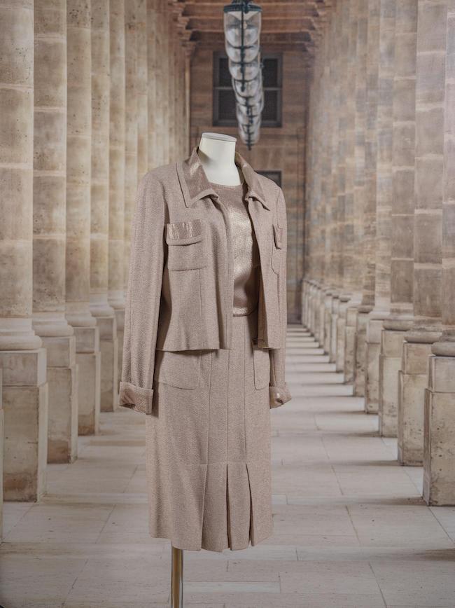 Chanel, collection Prêt à Porter Croisière 2000. Ensemble tailleur jupe en tweed beige et soie à poids dorés. Directeur artistique : Karl Lagerfeld.